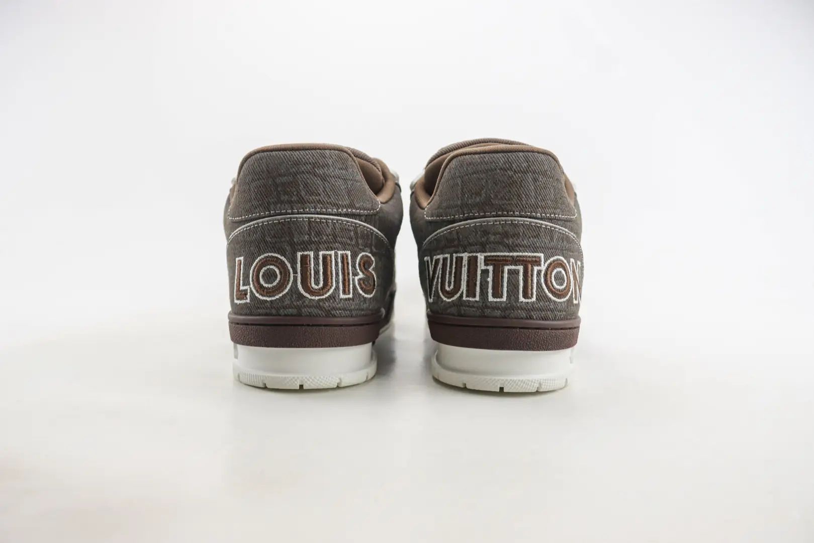 Louis Vuitton Trainer limited edition low-cut casual board shoes, featuring brown patterned design and prominent "LOUIS VUITTON" branding on the heel.
