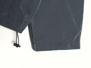 Dior Men's Technical Fabric Hooded Jacket featuring a close-up view of the hem and drawstring detail, showcasing the sleek design and high-quality materials.