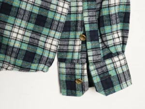 Celine green plaid flannel shirt featuring two flap pockets and gold buttons, showcasing a casual style ideal for layering.