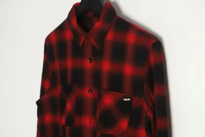 No brand visible on red black checkered flannel shirt cotton material with black buttons hanging on hanger