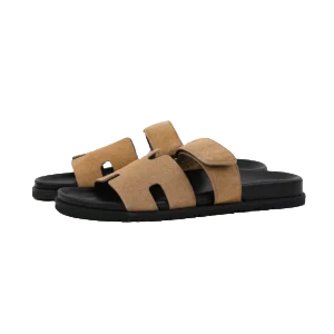 Hermes slippers in brown suede with a flat sole, showcasing a stylish open-toe design, ideal for luxury footwear enthusiasts.
