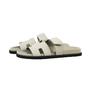 Hermes flat one-word slippers in light beige color, featuring a classic design with dual straps, suitable for luxury footwear collection.