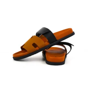 Hermes slippers featuring an orange and black design, showcasing a flat sole and stylish cutouts, ideal for luxury footwear enthusiasts.