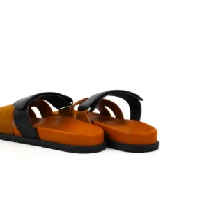 Hermes slippers featuring a sleek black strap and orange sole, showcasing luxury design and comfort, available in various sizes and colors for pre-sale.