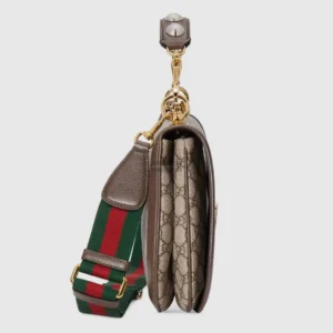 Gucci handbag featuring Double G interlocking design, beige and brown GG Supreme canvas, with a stud handle and striped canvas strap.