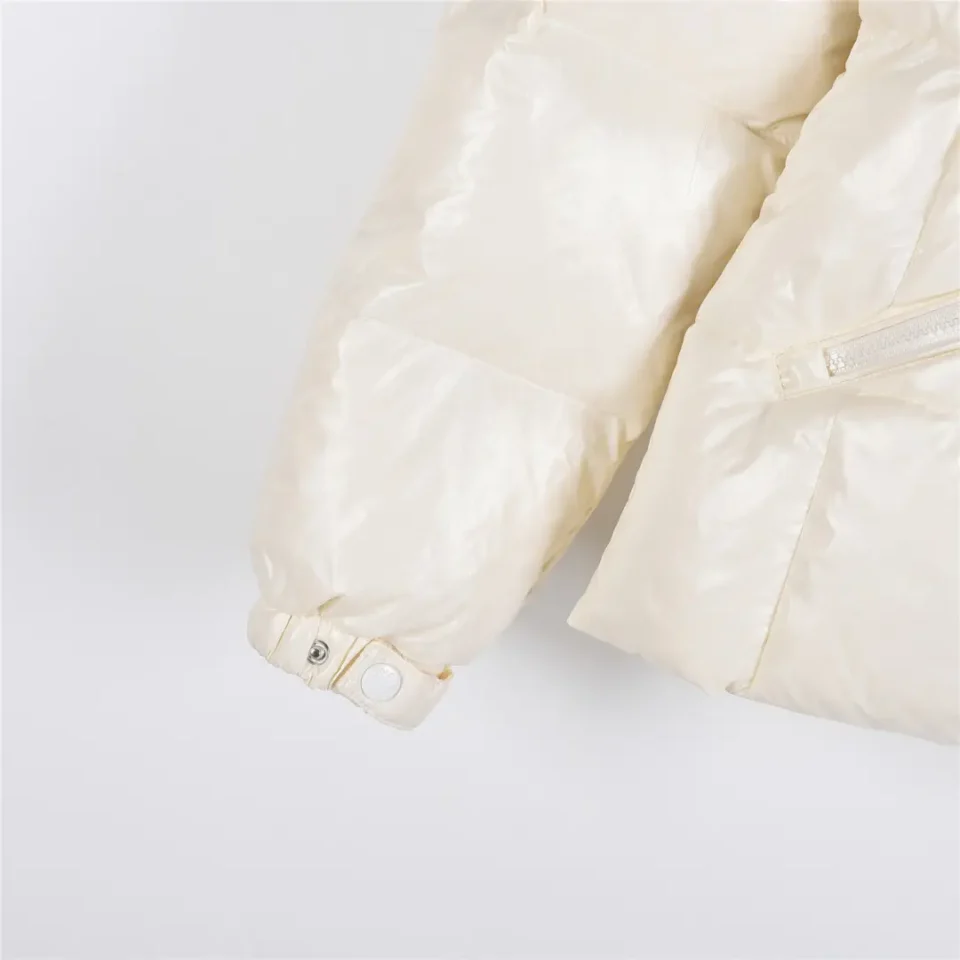 No brand or model details visible to create SEO-optimized alt text for this white puffer jacket sleeve.