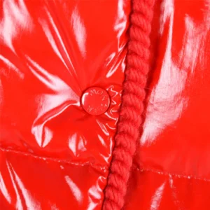 Close-up of a shiny red jacket featuring a button and braided detail, highlighting the design elements of the Moncler Second Generation Small Waist with Black Details.