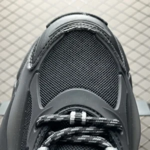 Close-up view of Pharrell x AD Adistar Jellyfis sneaker showcasing black mesh upper, intricate detailing, and textured design elements, emphasizing luxury footwear aesthetics.