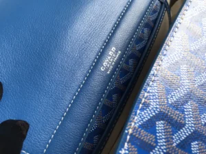 Close-up of Goyard Rouette bag showcasing blue leather interior and patterned exterior, highlighting craftsmanship and design details.