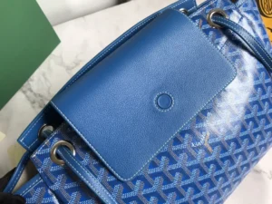 Close-up of Goyard's Rouette bag featuring a blue patterned design, leather accents, and distinctive hardware, emphasizing its luxurious craftsmanship and versatility.