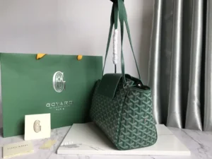 Goyard Rouette bag in green with signature pattern, displayed next to branded packaging and a card, showcasing luxury accessories and craftsmanship.