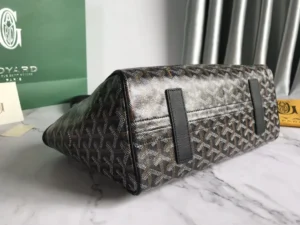 Goyard Rouette bag showcasing the unique textured design and quality materials, featuring contrasting leather accents and positioned on a marble surface.