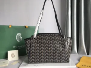 Goyard Rouette bag displayed on a marble surface, featuring a unique pattern, thickened rain dew hemp fabric, and a contrasting leather strap, with a green Goyard shopping bag in the background.