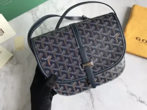 Goyard Belv é d è re Single Mailman Bag with distinctive pattern and narrow buckle, showcasing minimalist design and premium craftsmanship, placed on a marble surface.