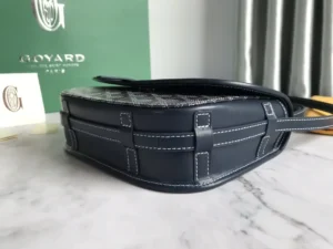 Goyard Belv é d è re Single Mailman Bag showcasing sleek design, high-quality leather, and minimalist style on marble surface with brand logo in background.