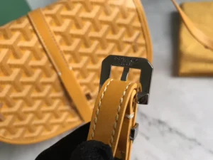 Goyard Belv é d è re Single Mailman Bag featuring a yellow textured exterior, adjustable strap, and metal buckle detail, highlighting its elegant design and craftsmanship.