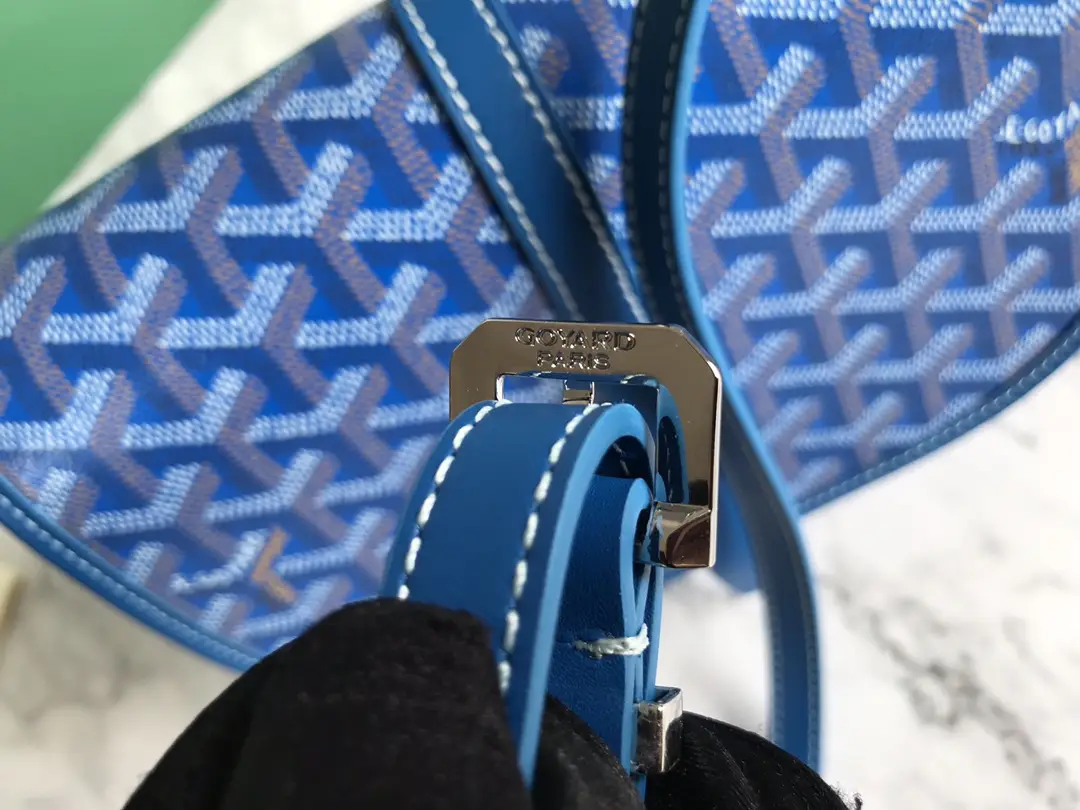 Goyard Belv é d è re Single Mailman Bag featuring blue patterned fabric, metal buckle detail, and leather strap, highlighting luxury design and craftsmanship.