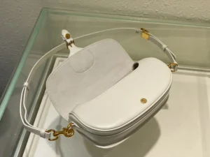Dior Bobby East-West bag in white leather with detachable shoulder strap, showcasing luxury design and versatile styling options.