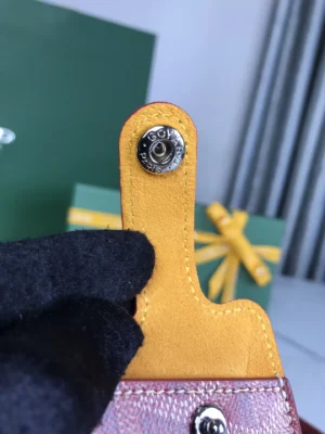 Goyard accessory yellow leather with silver snap button closure detailed with Goyard Paris engraving