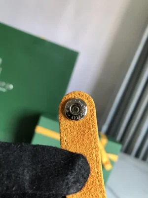 Goyard accessory yellow leather snap button strap with embossed logo hardware detail