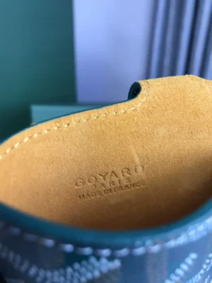 Interior view of Goyard MontMartre GM Green bag showing embossed logo "Goyard Paris Made in France" on soft yellow lining, highlighting luxury craftsmanship and authenticity.