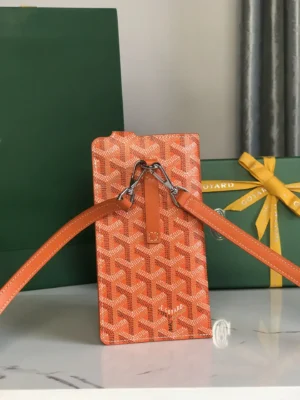 Goyard MontMartre GM bag in orange with a patterned design, featuring adjustable straps and placed beside a green Goyard gift box.
