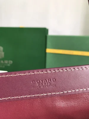 Goyard tote bag interior featuring embossed logo "Goyard Paris Made in France" with green packaging in background, emphasizing luxury branding.