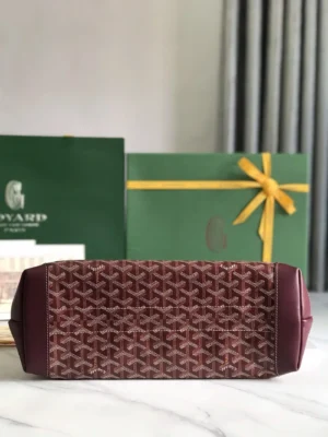 Goyard Tote Bag Commuter Series in burgundy with signature pattern, displayed with branded green packaging and yellow ribbon, emphasizing luxury and style.
