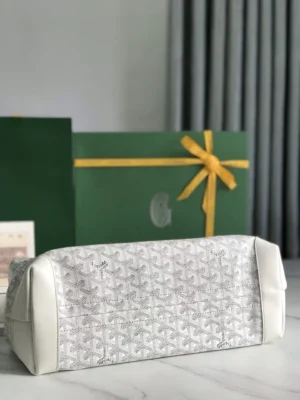 Goyard Tote Bag Commuter Series featuring a white and gray patterned exterior, displayed against a green gift box with a yellow ribbon, emphasizing luxury and style for commuting.