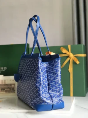 Goyard Tote Bag Commuter Series in blue, featuring a spacious design, dual handles, and decorative patterns, set against a green gift box with a yellow ribbon.