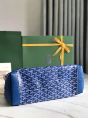 Goyard Tote Bag Commuter Series in blue, featuring signature pattern, with protective cover and stylish design, set against a green gift box with yellow ribbon.
