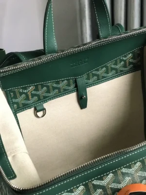 Goyard Cisalpin Backpack interior view showcasing green Goyardine canvas and leather detailing, featuring zipper closure and spacious compartment for personal items.