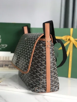 Goyard Citadin Mailman Bag featuring a geometric pattern, leather accents, and a versatile design, displayed on a marble surface with gift boxes in the background.