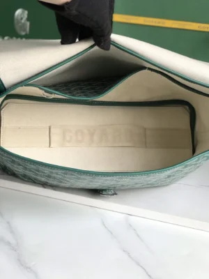 Interior view of Goyard Citadin Mailman Bag showcasing green lining and embossed logo, emphasizing functionality and style for versatile use.