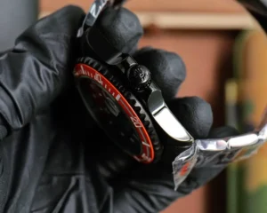 Rolex Submariner black dial red ceramic bezel stainless steel watch with protective glove hand holding