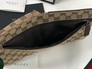 Brown leather handbag with Gucci logo, showcasing interior design and zipper details, on a branded surface, representing a classic designer women's bag.