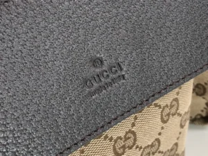 Close-up of Gucci logo on a brown leather handbag, showcasing designer craftsmanship and materials.
