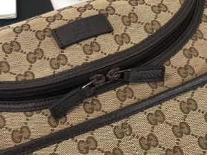 Close-up of a Gucci Premium GG Canvas Leather Tote featuring the signature GG pattern, zipper detail, and brown leather accents.