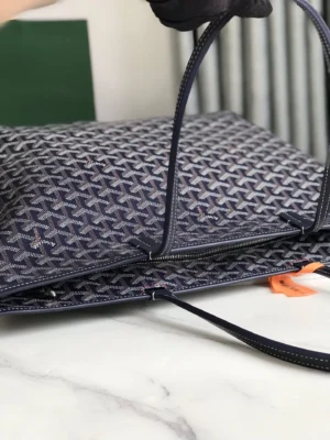 Goyard Tote bag featuring signature pattern and dual handles, displayed on a marble surface, emphasizing its quality and design.