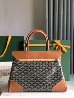 Goyard Saigon Tote bag featuring a grey patterned body with brown leather accents, displayed against green gift boxes, highlighting its elegant design and luxury appeal.