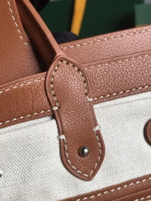 Close-up of Goyard Saigon Tote bag's leather strap detail, showcasing stitching and texture, emphasizing luxury craftsmanship.