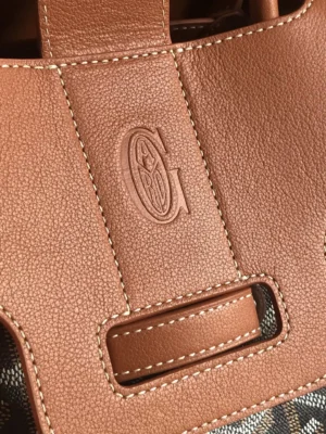 Goyard Saigon Tote bag close-up showcasing embossed logo on leather handle and stitching details.