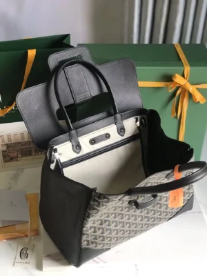 Goyard Saigon Tote bag displayed open, showcasing its spacious interior and elegant design, with a stylish black and gray pattern, alongside green packaging and accessories.