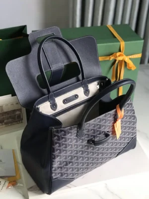 Goyard Saigon Tote Bag in navy, showcasing elegant design, spacious interior, and luxury branding, with gift box in background.