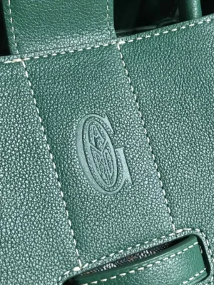 Goyard Saigon Tote bag detail featuring embossed logo on textured green leather, highlighting luxury craftsmanship and design.