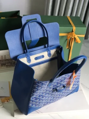 Goyard Saigon Tote bag in blue with a unique pattern, open to showcase its spacious interior, set against a backdrop of green packaging and elegant presentation.