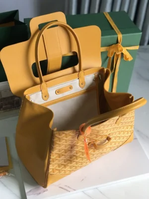 Goyard Saigon Tote bag in yellow, showcasing elegant design, spacious interior, and stylish accents, placed next to a green gift box.