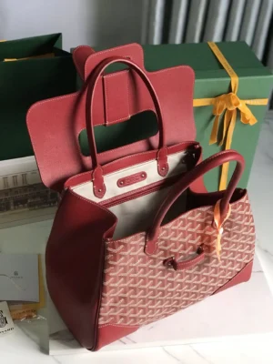 Goyard Saigon Tote bag in red and beige with distinctive logo pattern, displayed alongside green gift boxes, showcasing its elegant design and spacious interior.