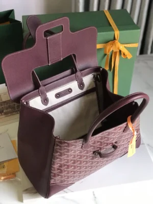 Goyard Saigon Tote bag in burgundy, showcasing interior design and spacious capacity, with packaging elements in the background.