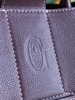 Goyard logo embossed on textured brown leather of the Saigon Tote bag, highlighting luxury craftsmanship and design.